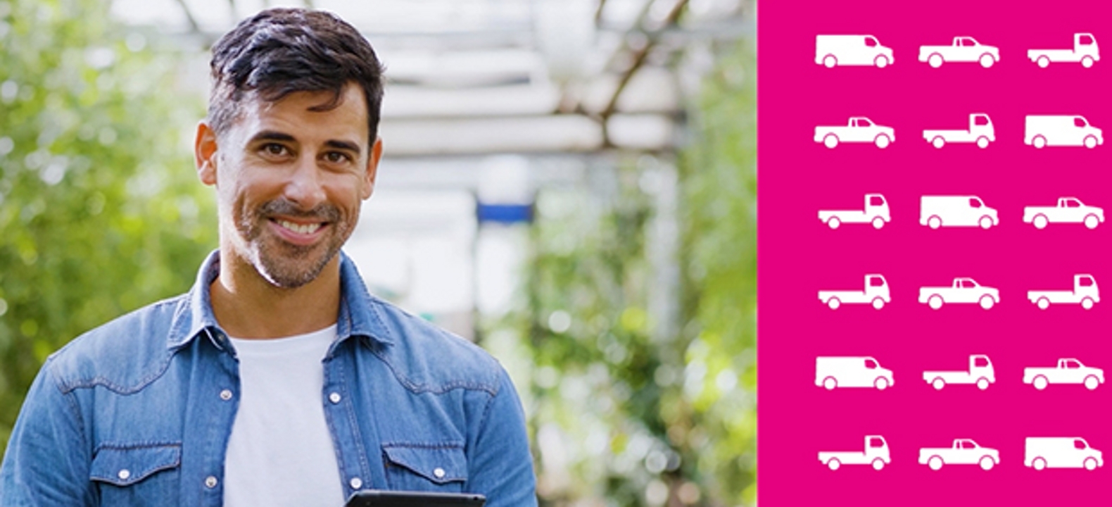 Hombre con camisa de denim azul sonríe a la cámara mientras sostiene una tablet en un invernadero con una representación gráfica de diferentes tipos de camiones y furgonetas de flota.