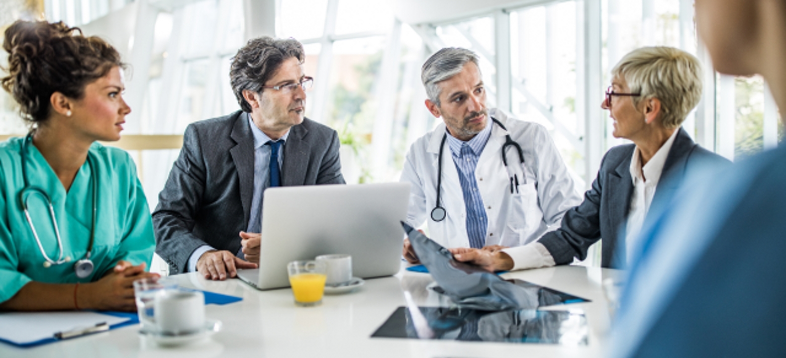 Ejecutivos de un hospital y profesionales médicos se reúnen en una sala de conferencias.