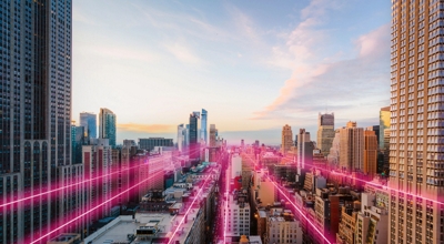 Rayos magenta proyectados desde un horizonte urbano para indicar la conectividad 5G.