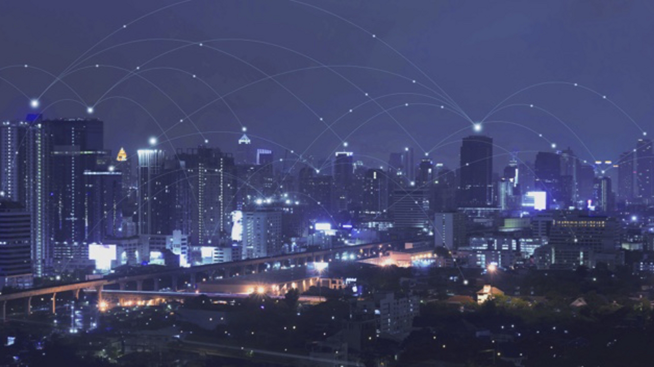 Una silueta urbana nocturna superpuesta con una red de conectividad 5G.