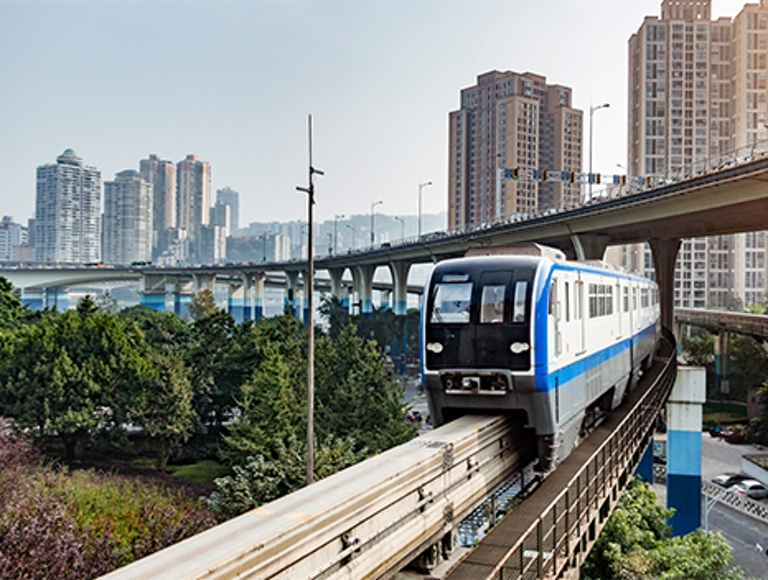 Persona vestida con un atuendo de negocios mira su teléfono dentro de una oficina de plano abierto.