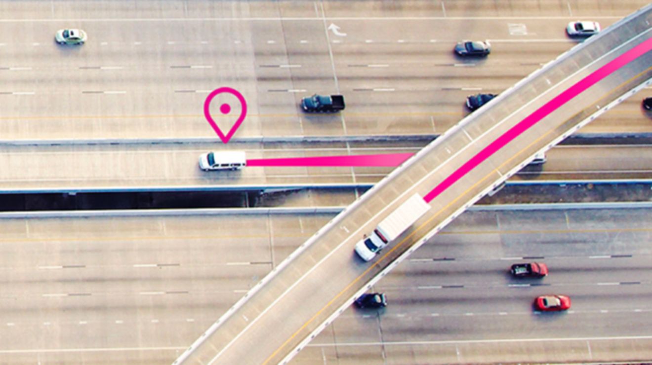 Vista aérea de dos camiones blancos en la carretera con un ícono de ubicación y líneas magenta detrás de los vehículos