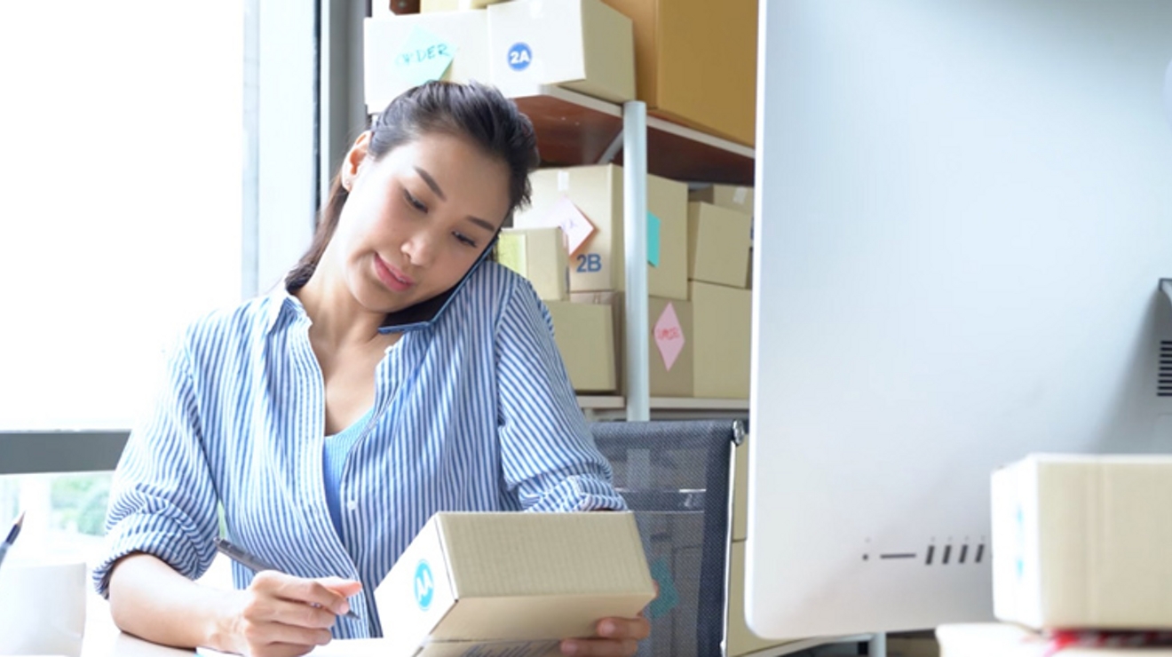 Mujer con camisa de rayas mira una caja