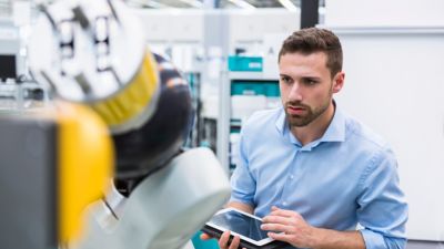 Un ingeniero usa una tablet para operar maquinaria en un laboratorio.