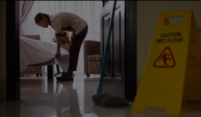Empleada doméstica haciendo la cama en una habitación de hotel