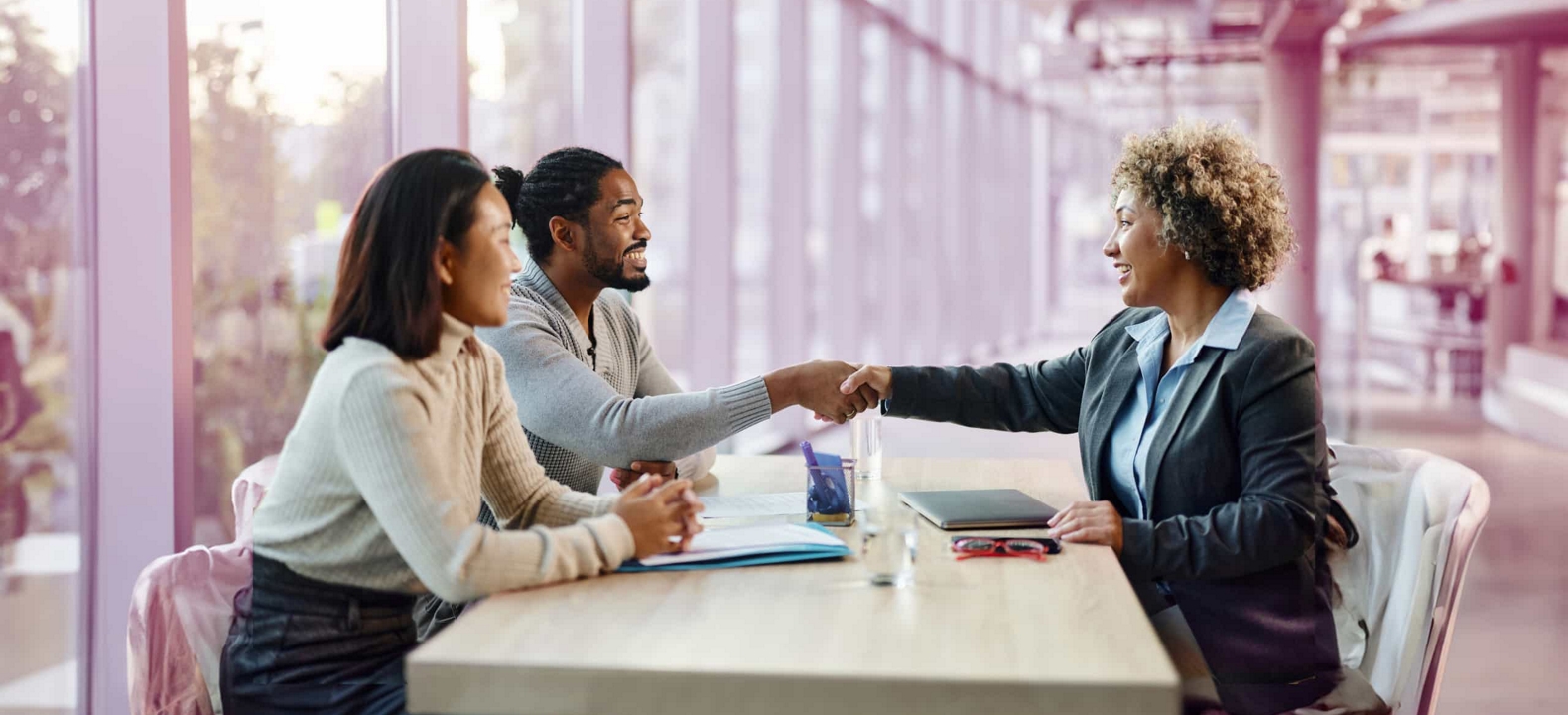 Un nuevo empleado estrecha con alegría la mano de su empleador al final de una entrevista satisfactoria.<br>