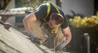 Un trabajador instalando paneles solares en un tejado.