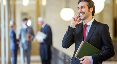 Un profesional habla con su smartphone en el pasillo de una compañía.