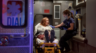 Un miembro del equipo de emergencias médicas atiende a un paciente en la ambulancia.