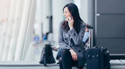 Un profesional atiende una llamada de negocios desde un aeropuerto internacional.
