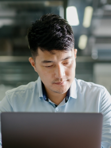 Un profesional trabaja con su laptop en un espacio de trabajo abierto.