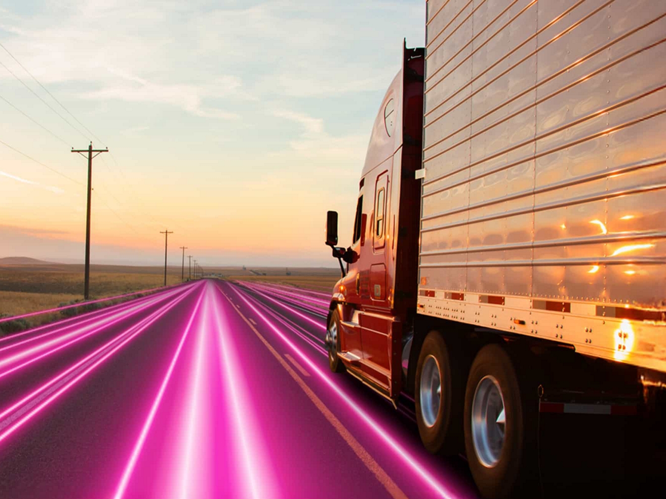 Un semirremolque recorre una solitaria autopista de color magenta al amanecer.