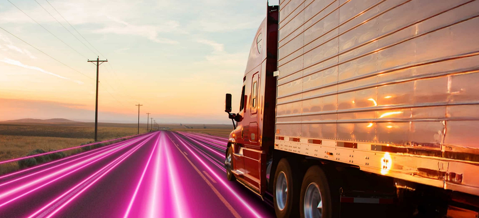 Un semirremolque recorre una solitaria autopista de color magenta al amanecer.