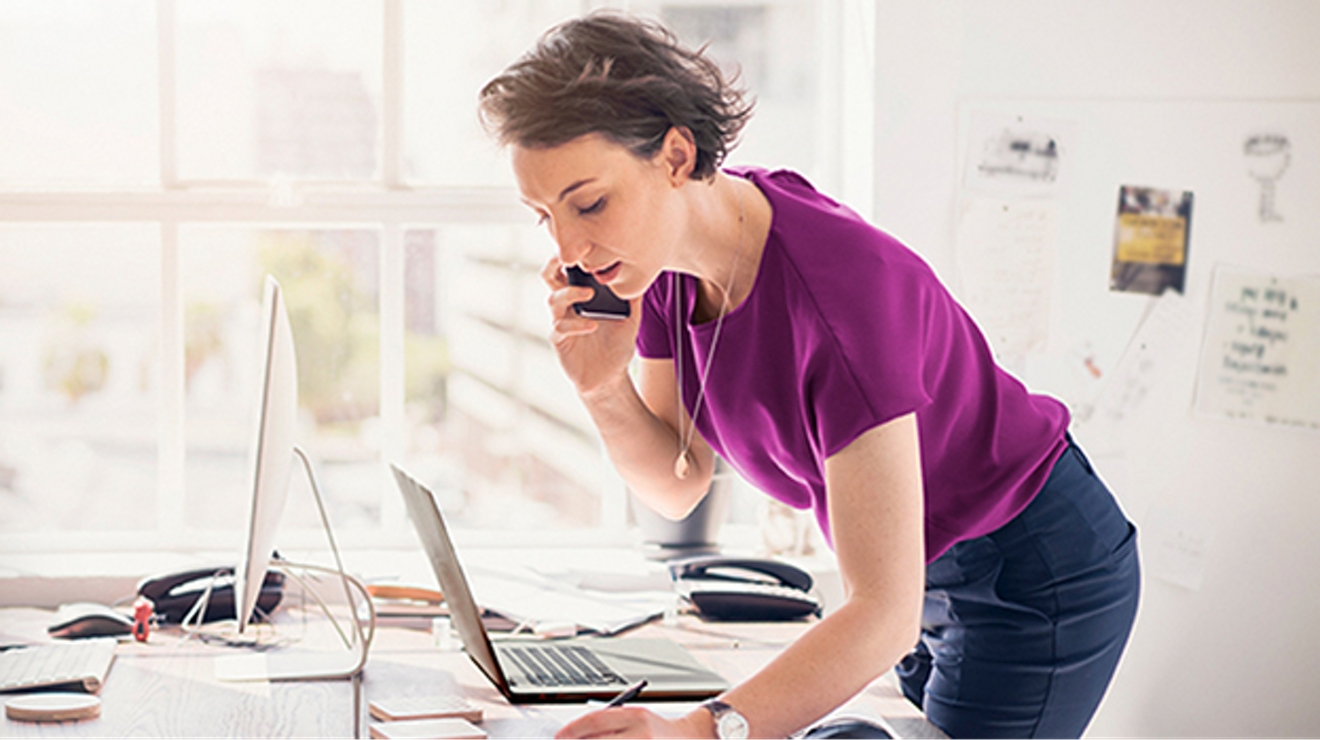 Mujer hablando por teléfono en su escritorio