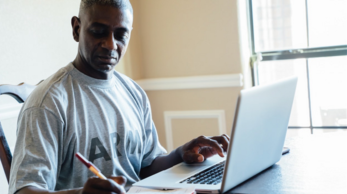 Hombre escribiendo y una laptop