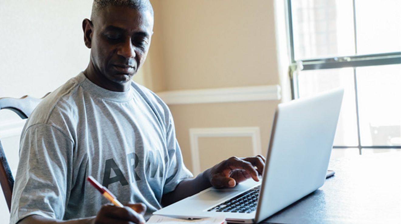 Hombre escribiendo y una laptop