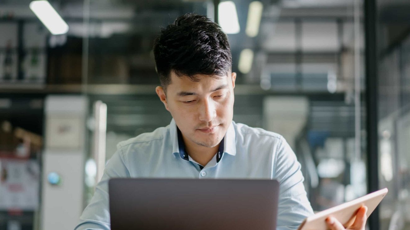 Un hombre de negocios utiliza su laptop y tablet mientras sus herramientas y datos están perfectamente protegidos.