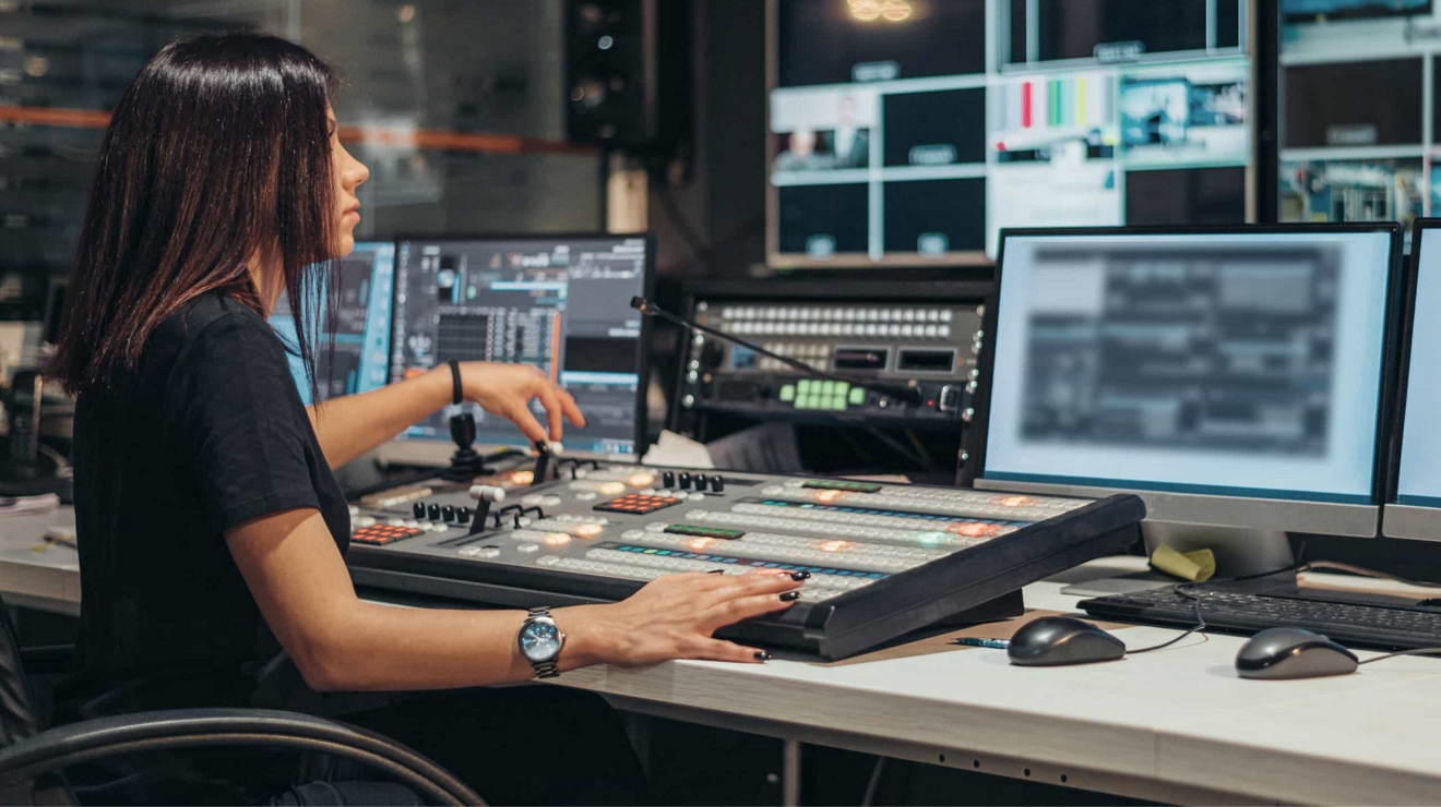 Una profesional de los medios de comunicación trabajando en la sala de control de una cadena de televisión