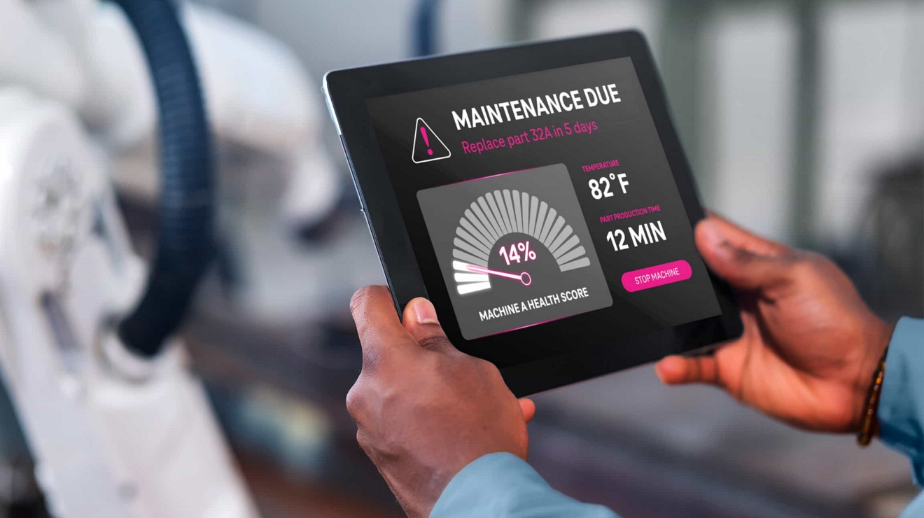 Trabajador de una planta de producción utiliza una tablet para revisar una actualización de estado de mantenimiento para un equipo.