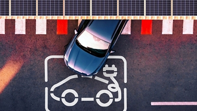 Vista aérea de un vehículo eléctrico en la estación de carga de un estacionamiento.
