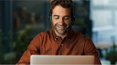 Un funcionario del gobierno utiliza sus auriculares durante una videollamada en una laptop.