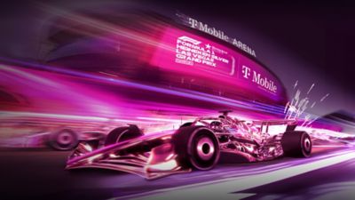Un auto de Fórmula 1 magenta corriendo en una pista magenta fuera del T-Mobile Arena.