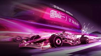 Un auto de Fórmula 1 magenta corriendo en una pista magenta fuera del T-Mobile Arena.