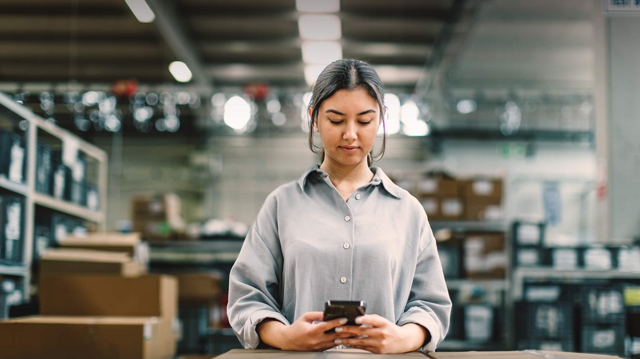 Un empleado de correos utiliza el teléfono móvil como herramienta de trabajo.