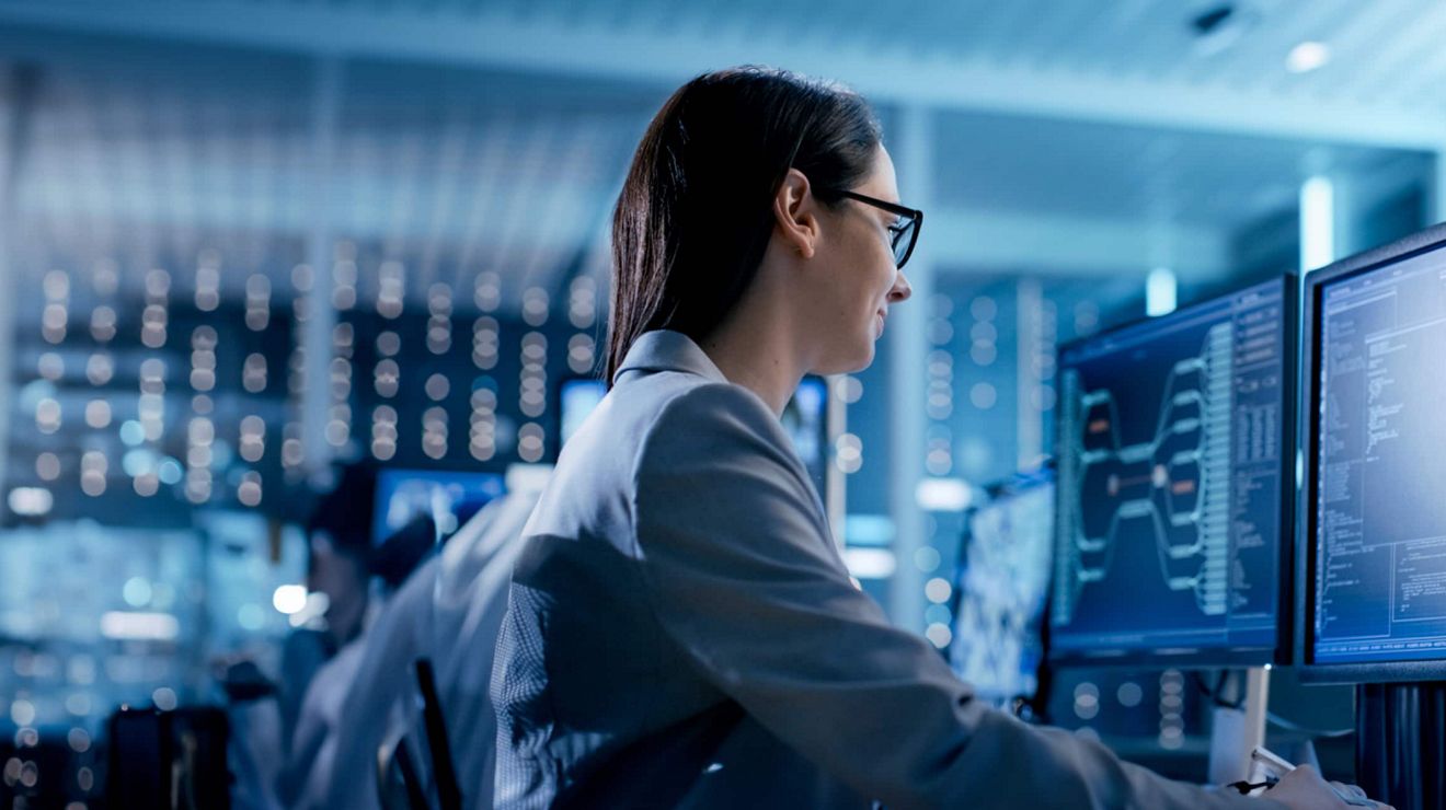 Un ingeniero de ciberseguridad de una empresa de servicios públicos revisa los datos técnicos que se muestran en los monitores de su estación de trabajo.