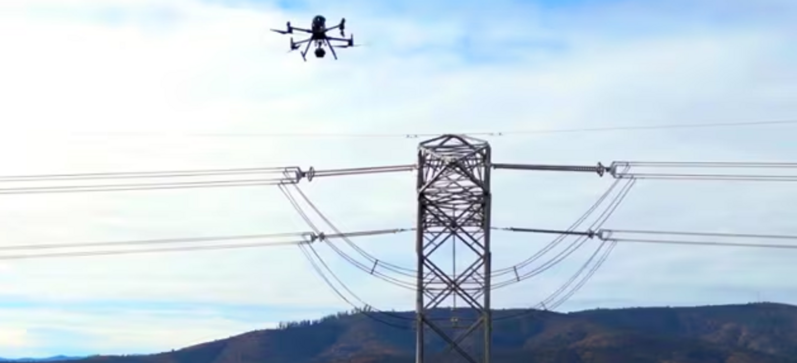 Un dron conectado sobrevuela un apoyo de línea eléctrica usando visión por computadora para ayudar a inspeccionar la infraestructura.