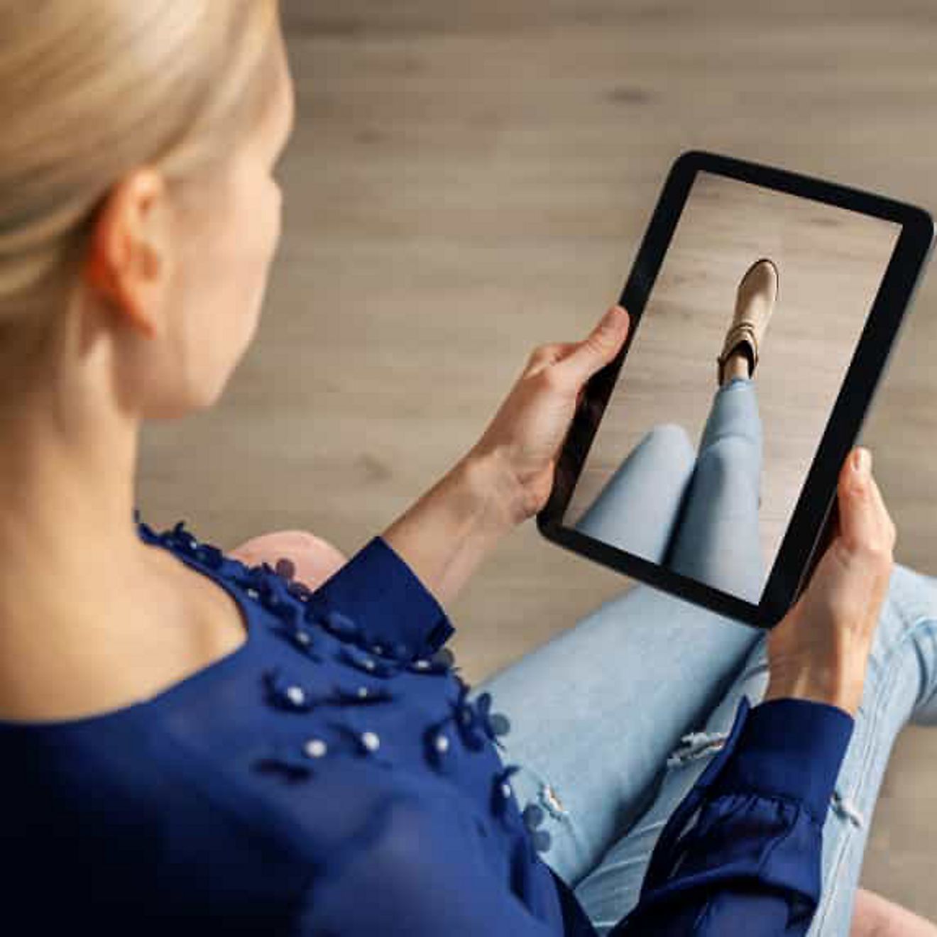 Una compradora utiliza una tablet y la realidad aumentada para probarse virtualmente un zapato.