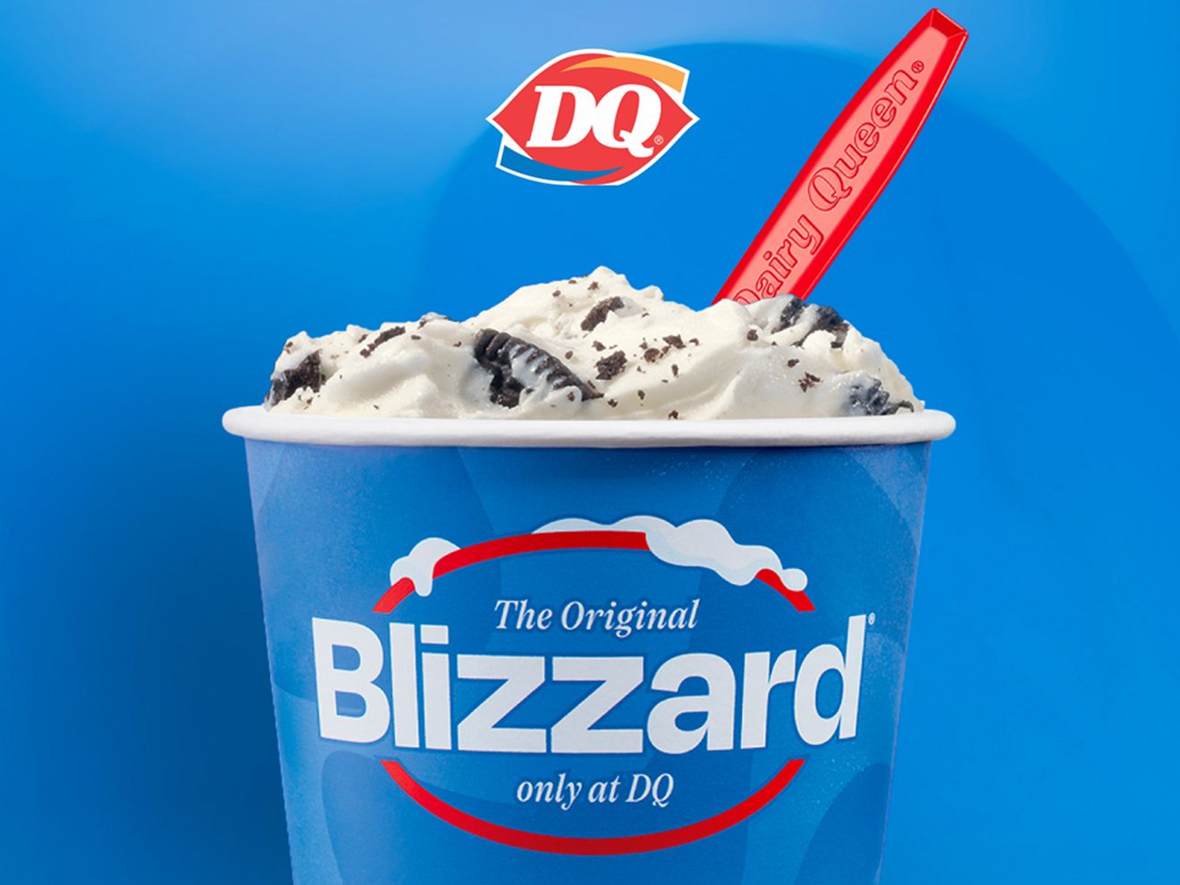 El Mini Blizzard original: helado cremoso mezclado con galletas de chocolate en un vaso azul brillante con una cucharita roja, solo en DQ.