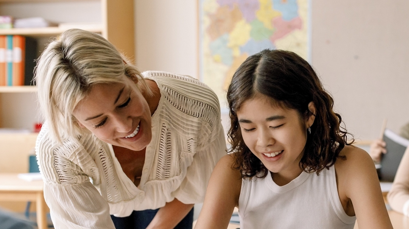 Maestra enseñando a estudiar en una tablet digital