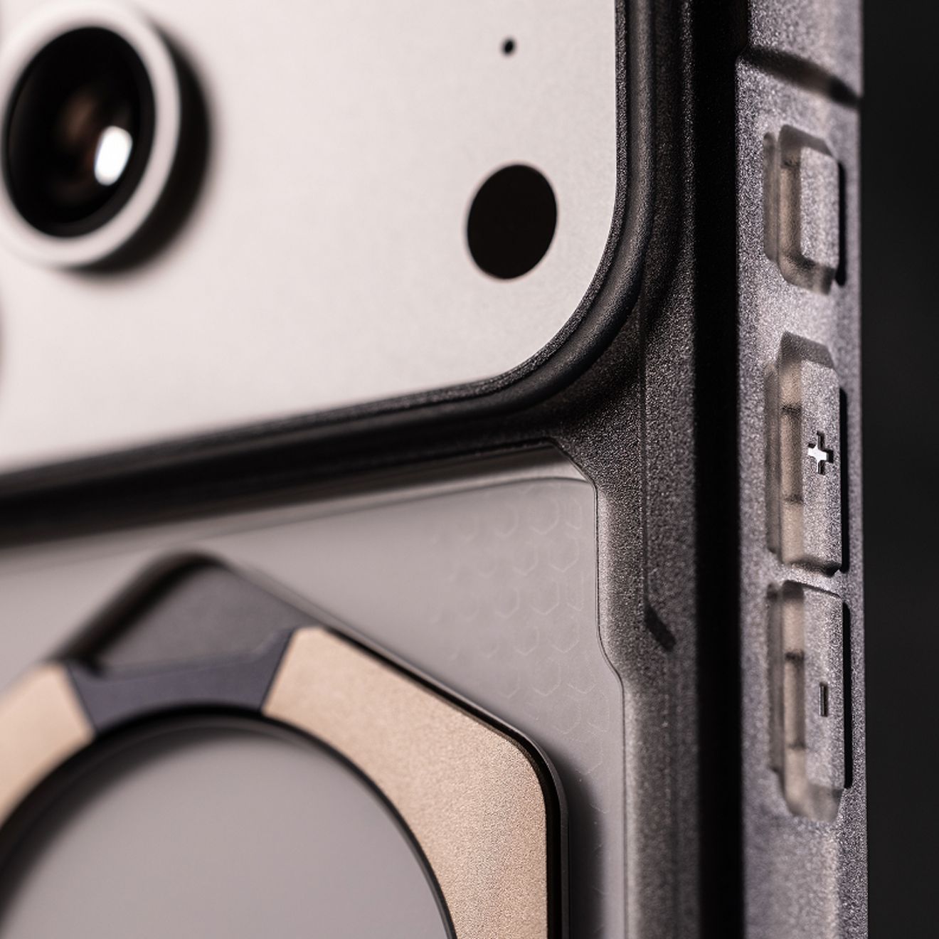 Primer plano de un iPhone con una funda UAG resistente, que destaca la protección elevada de la cámara, el borde reforzado y los botones laterales texturizados.