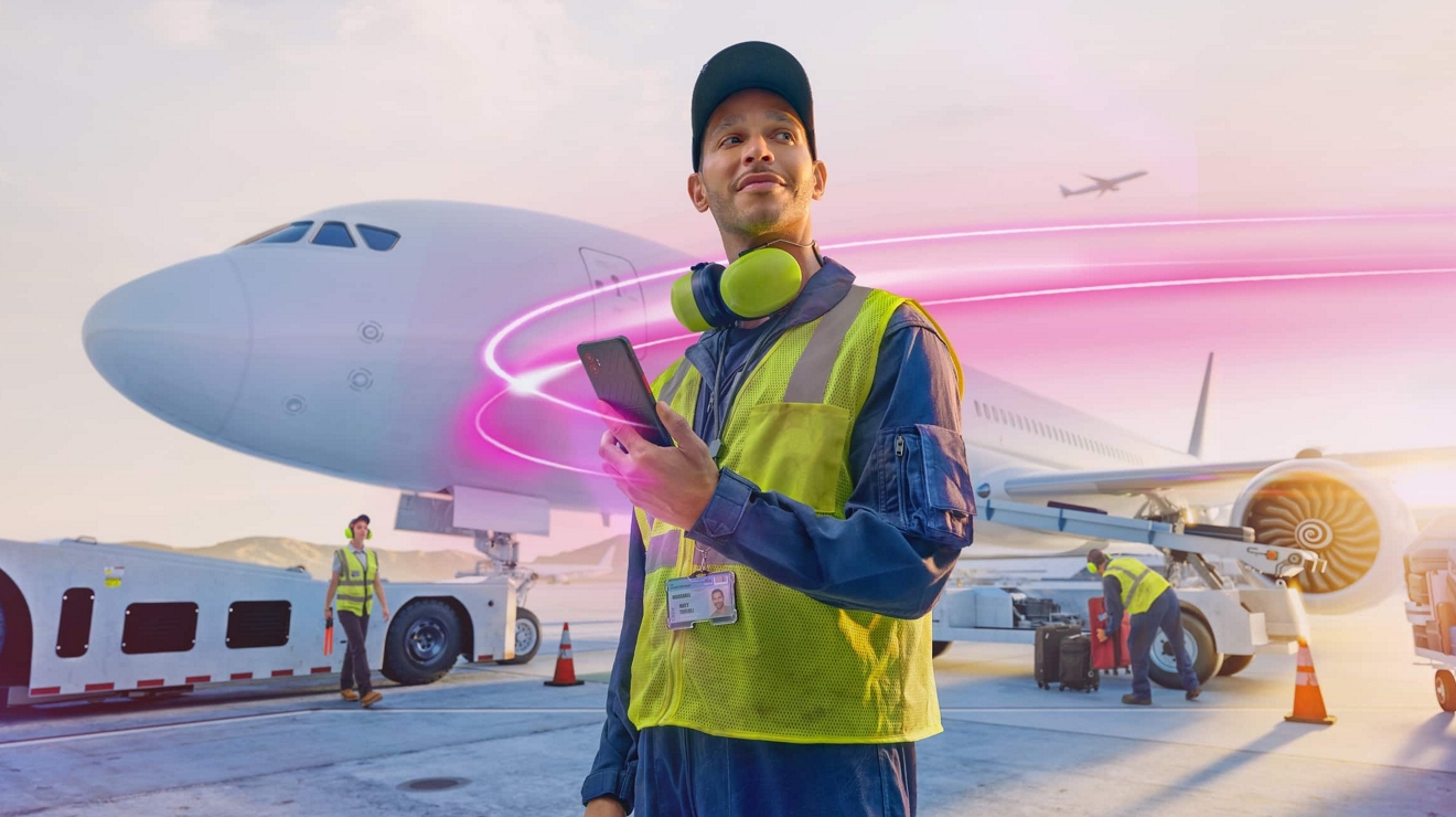 Un técnico de mantenimiento de una aerolínea proporciona una actualización del estado desde la pista de un aeropuerto en un smartphone.