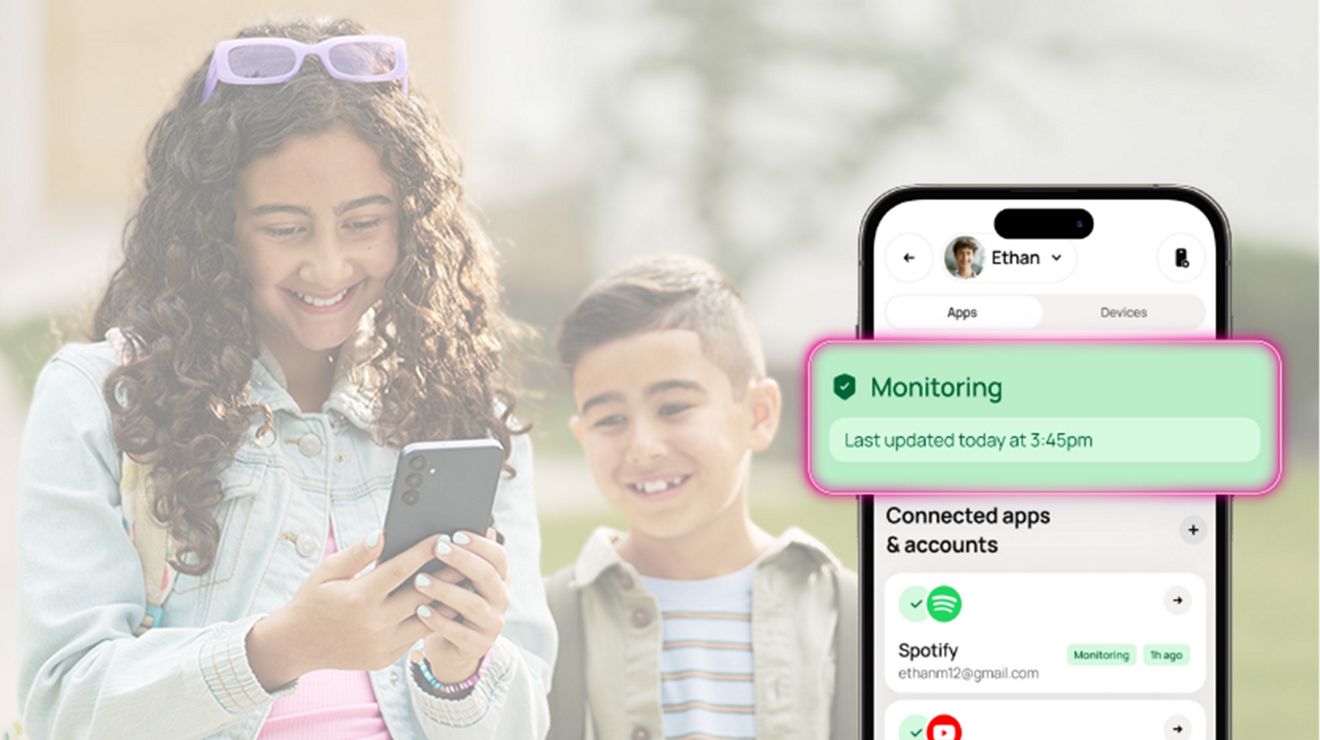 Una niña y un niño están sonriendo. Los dos están mirando el teléfono que tiene la niña.