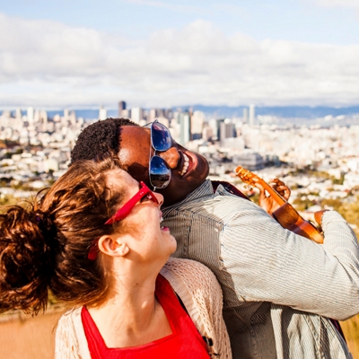 Pareja sonriendo y tocando un instrumento