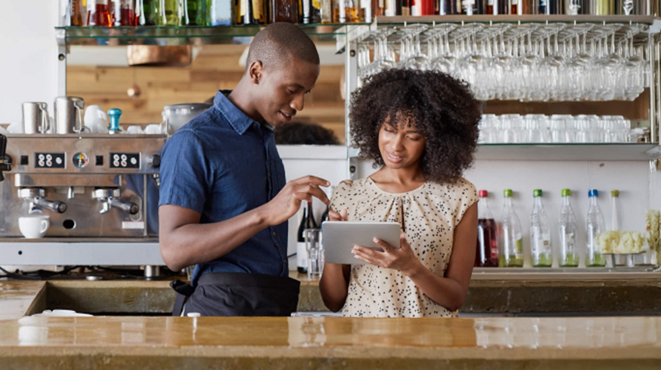 Los propietarios de un café local utilizan una tablet para enviar un pedido de suministros.