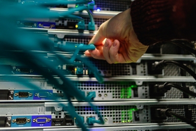 Una mano conectando cables de red