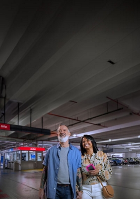 Una pareja camina por el estacionamiento de Dollar Car Rental.
