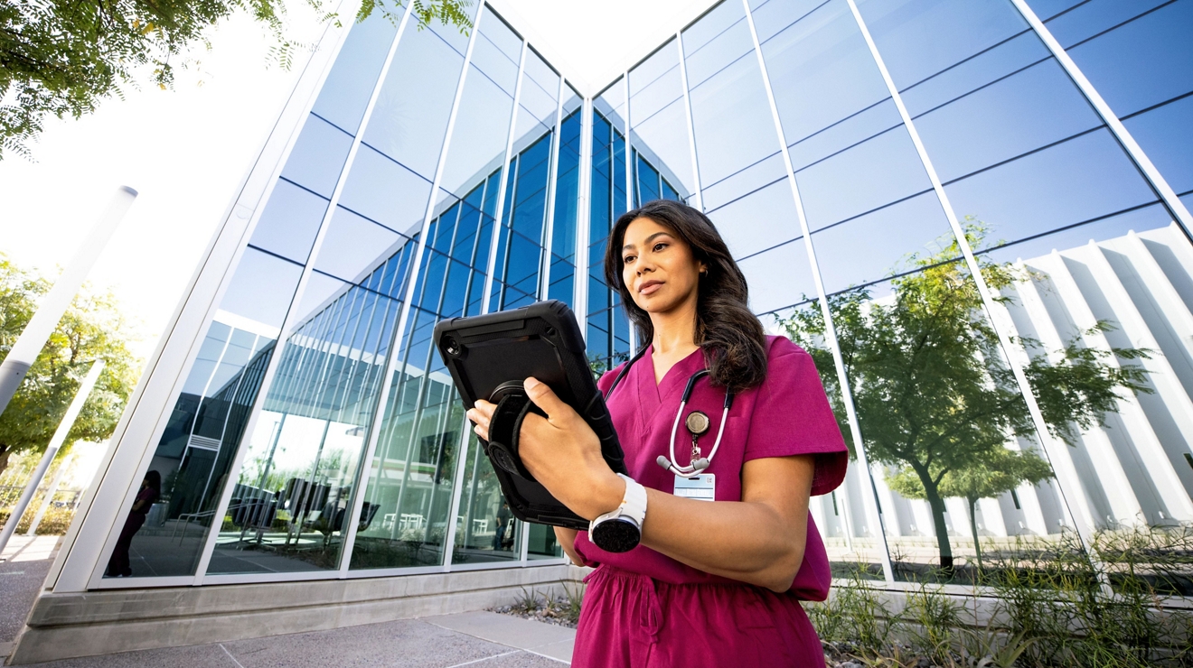 profesional médico en tablet frente al edificio