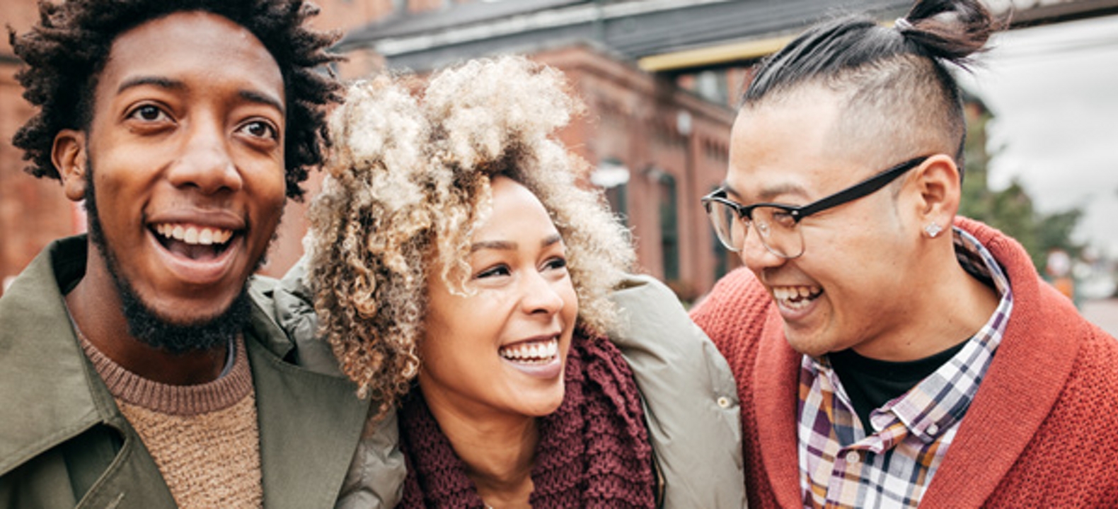 3 personas sonriendo al aire libre en la ciudad