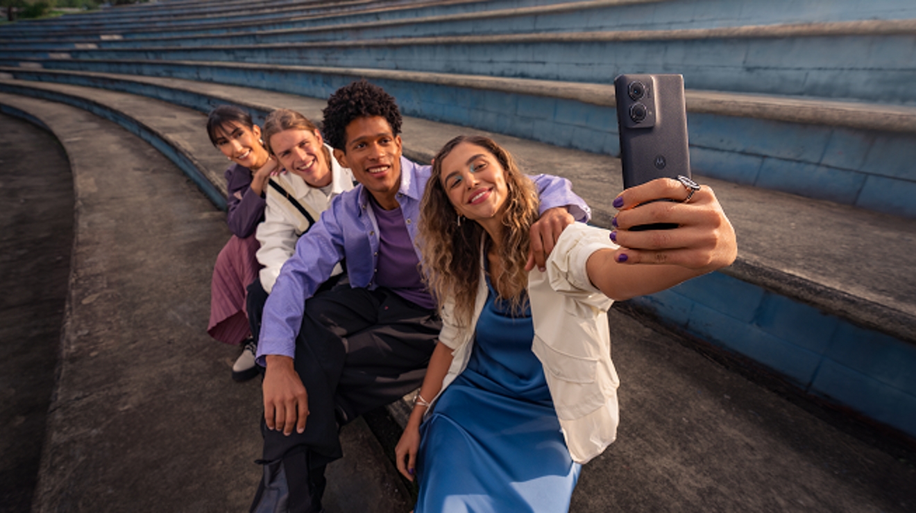 En las gradas, un grupo de cuatro amigos se toman un selfie.