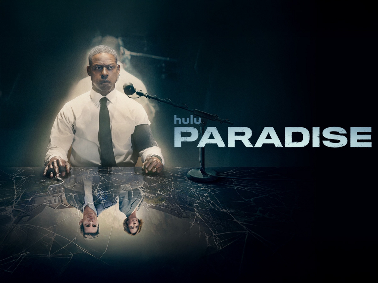 La serie de Hulu, Paradise, muestra a un hombre con camisa blanca y corbata sentado a una mesa con un espejo roto que refleja a otros dos personajes.