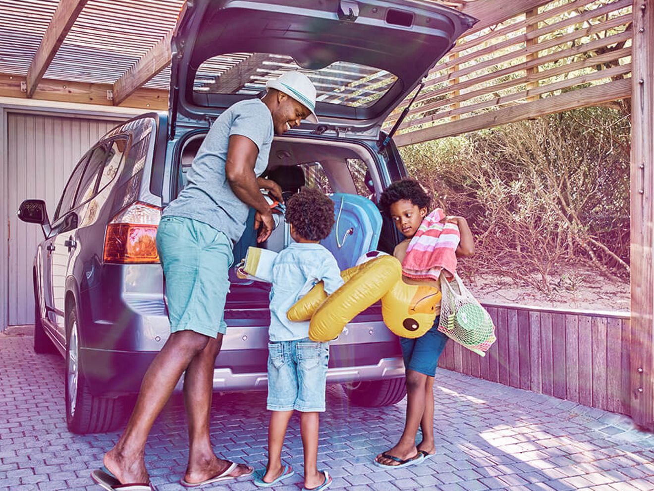 Una familia cargando el maletero de su auto para irse de vacaciones.