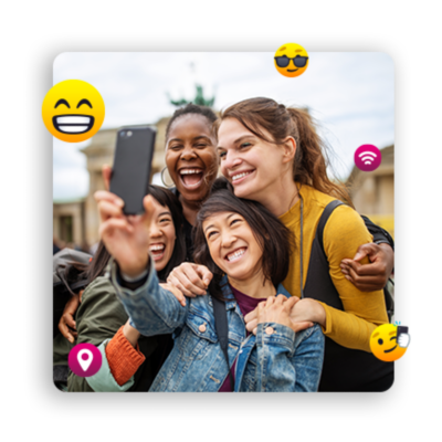 Cuatro mujeres jóvenes posando para un selfie grupal, rodeada de emojis.