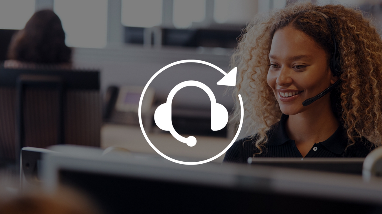 Experta en tecnología sonríe mientras chatea con un cliente a través de sus audífonos.