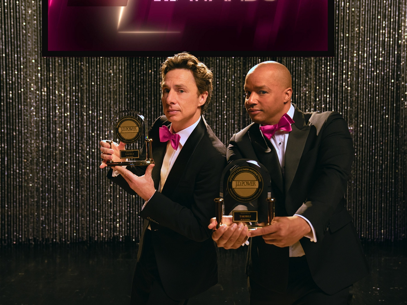 Los famosos Zach Braff y Donald Faison, ambos de esmoquin, muestran los premios de J.D. Power.