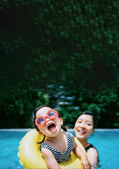 Madre e hija jugando con flotadores en una piscina