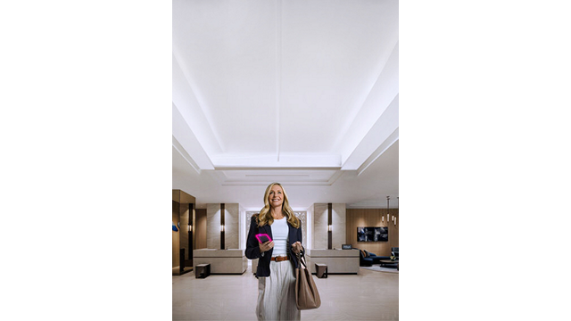 Una mujer parada en el vestíbulo del hotel Hilton con un bolso en la mano.
